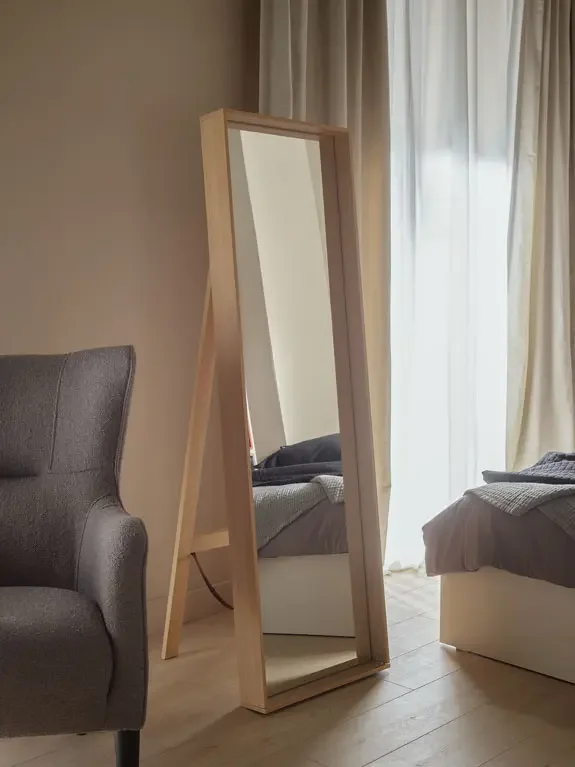 Lustro w drewnianej ramie – elegancki i funkcjonalny dodatek do przytulnej sypialni.